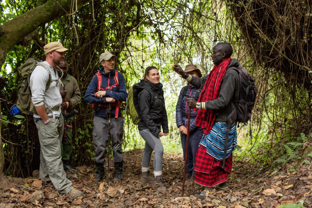 Alex our local guide explaining about the trees flowers plants and animals and how the Maasai use this as local medicine